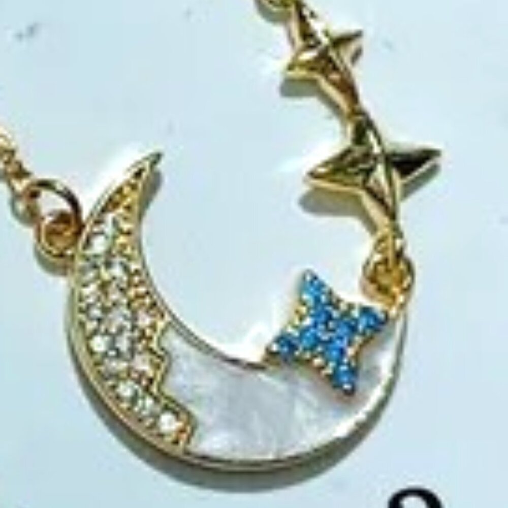 18K GOLD DIPPED MOON NECKLACE DANGLING  UP BY STARS ON THE CHAIN.